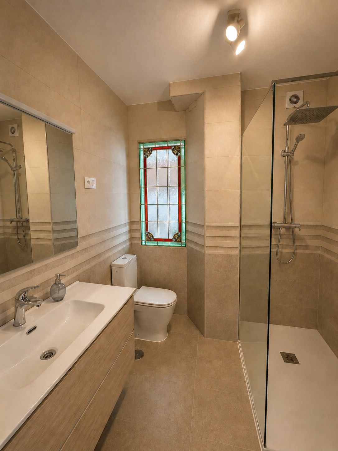 A bathroom with a stained-glass window and a walk-in rain shower.